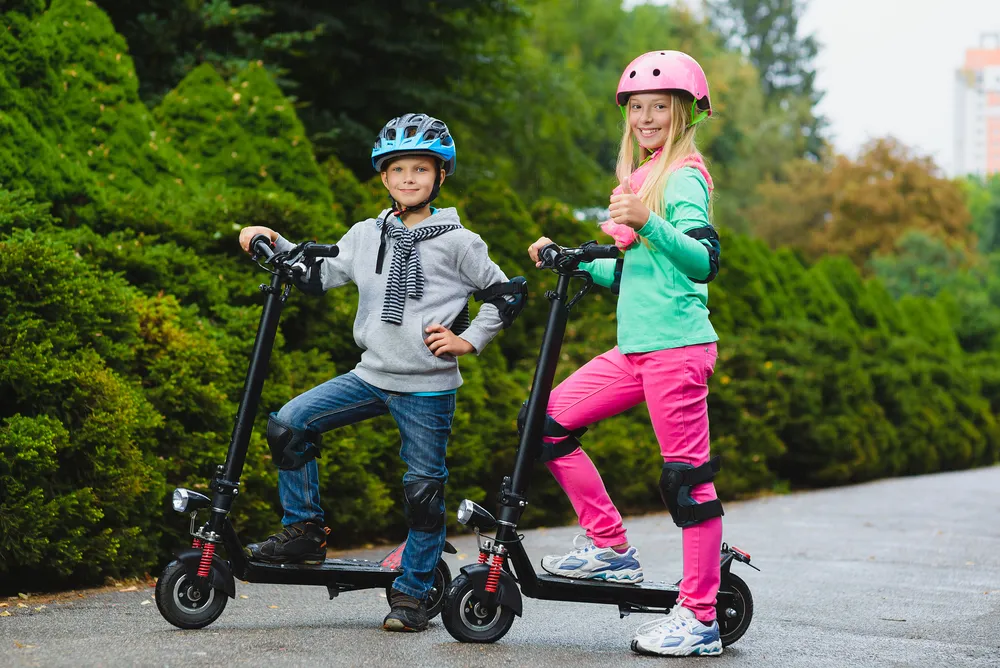 Kids standing on electric scooter outdoor
