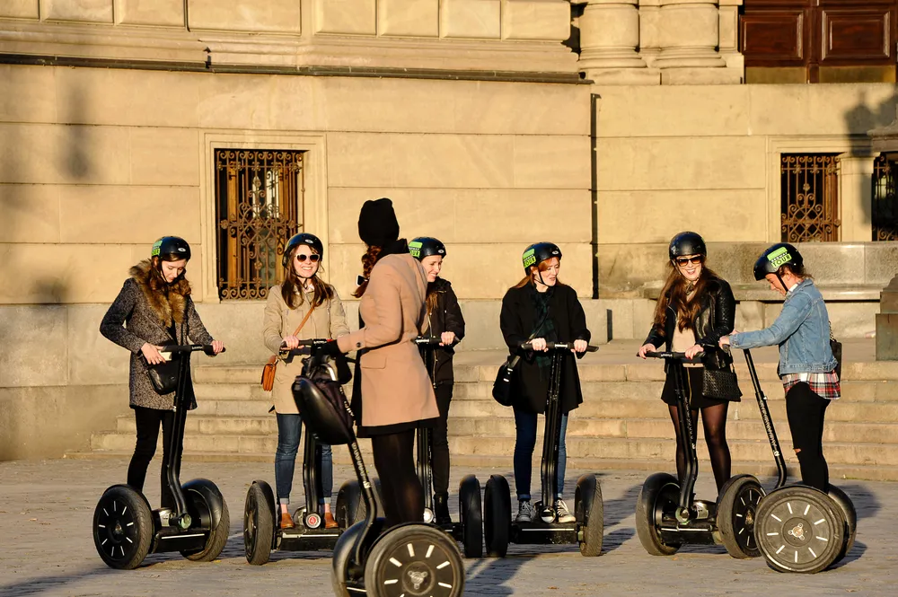 Tourists having guided sunset city tour on Segway scooters