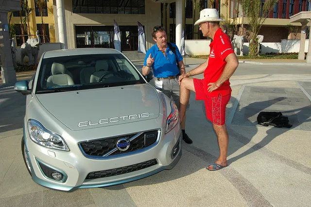 Volvo electric car with two person beside it