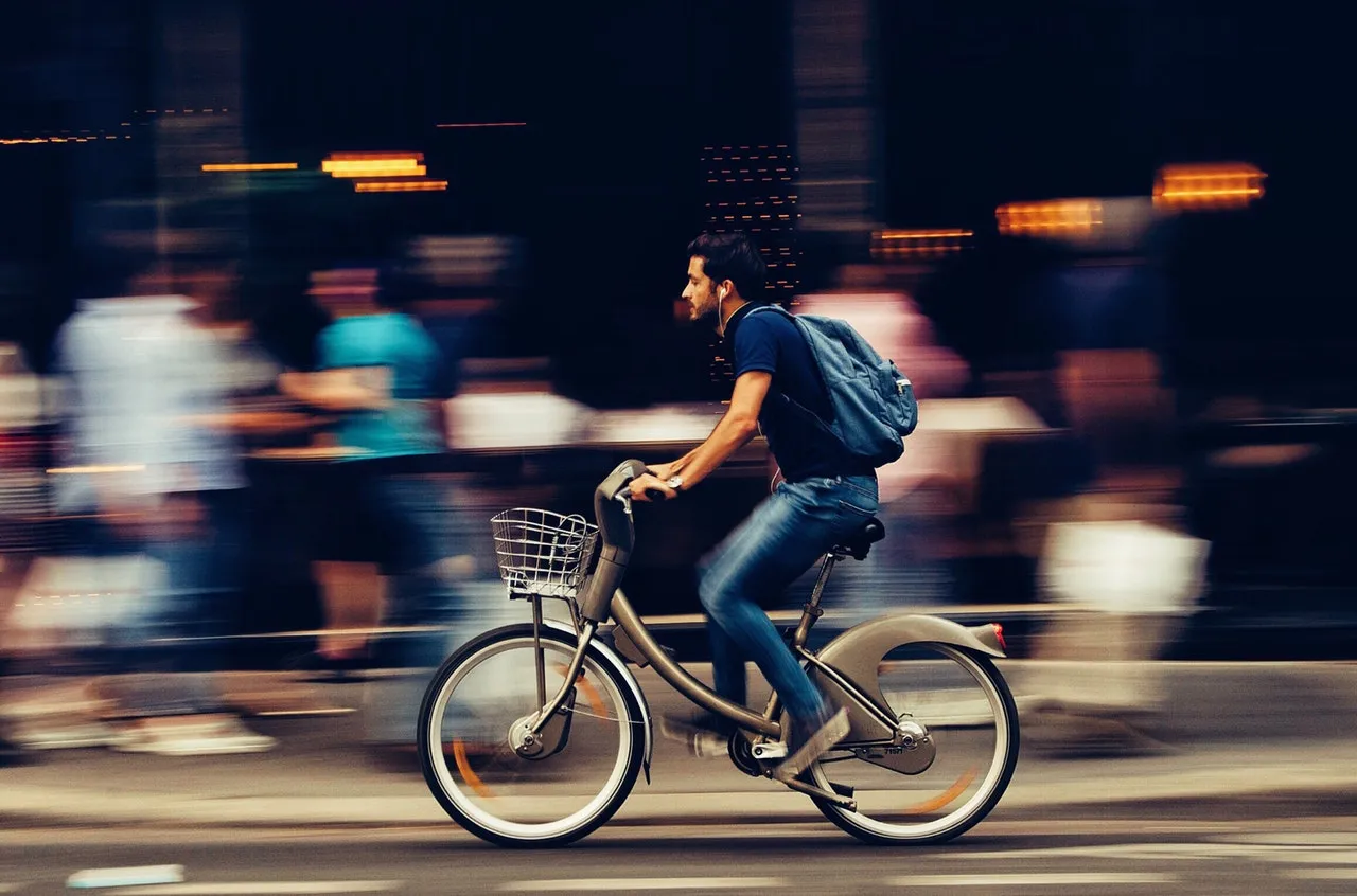 Man riding bicycle on city street