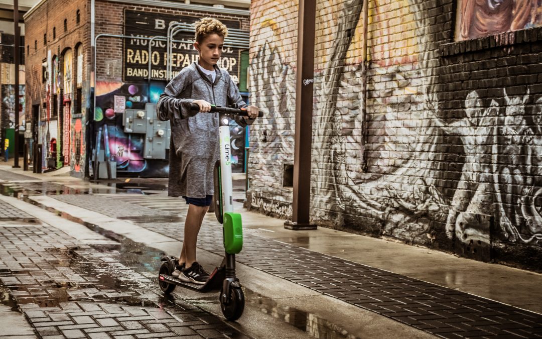 Boy standing on white and black kick scooter